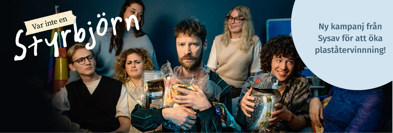 Styrbjörn sitter omringad av flera glada männsiskor medan han håller hårt i sina plastförpackningar.