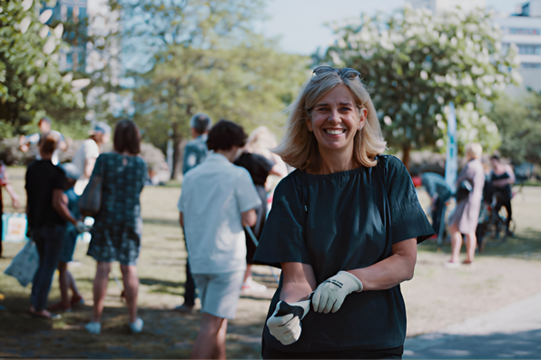 Bild på Johanna Ragnartz i en park fylld av människor som plockar skräp.