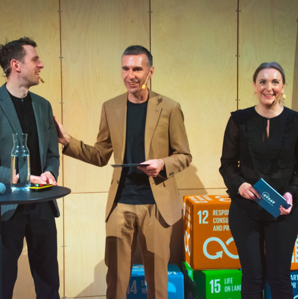 Ann och Rustan - konferansens moderatorer - på scen bredvid en talare, alla ler.