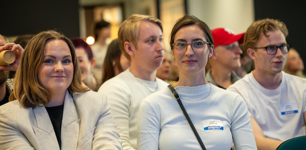 Översikt av publiken på Sysavdagen med människor som ler och lyssnar.