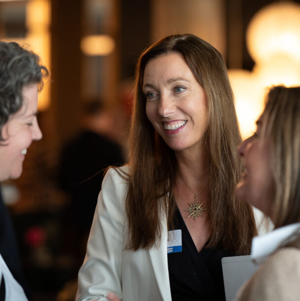 Tre kvinnor samtalar glatt under en paus.